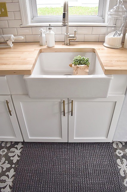 White Kitchen remodel with patterned tile and butcher block counter tops. Ikea farm sink.
